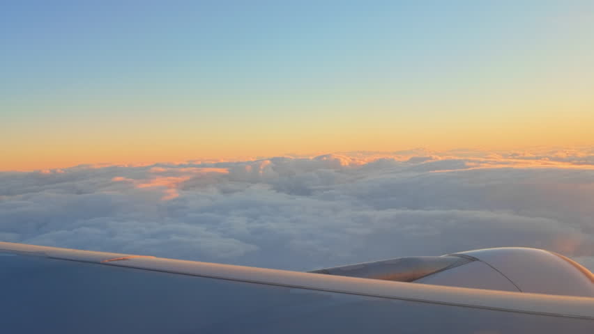 Sunset sky on airplane, Clouds and sky through window of an aircraft during flight. flight for relax and vacations in holiday concepts