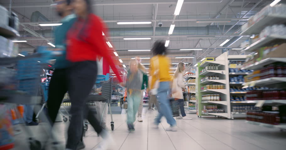 Families and Individuals from Various Backgrounds Shop Together in a Busy Supermarket. Customers Pick Up Canned Food and Packaged Goods while Comparing Prices. Time Lapse Footage