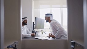 Cinematic video of two businessmen working together in a modern office in the united arab emirates. Business people with the traditional white kandura in Dubai giving an handshake about a close deal. - Powered by Shutterstock - Get 15% off with code: PIKWIZARD15