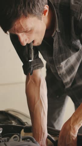 A focused mechanic works diligently with a flashlight over an engine, using precision tools to ensure the highest level of craftsmanship and efficiency.