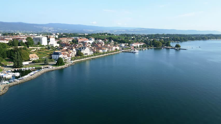 Push in drone shot of the port of Nyon with the castle and the Lake of Geneva.