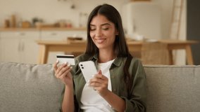 Happy smiling Indian woman Arabian girl client customer buyer female Muslim lady at home couch sofa kitchen shopping online mobile phone order food delivery enter number credit bank card buy purchase - Powered by Shutterstock - Get 15% off with code: PIKWIZARD15