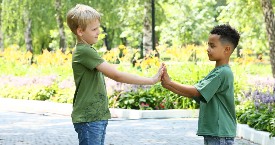 Two little boys play in summer park