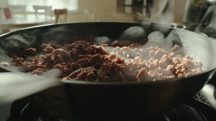 ground meat in pan steaming on gas stove