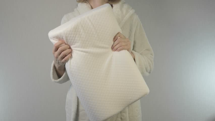 Woman with memory foam orthopedic pillow for healthy comfort sleeping.