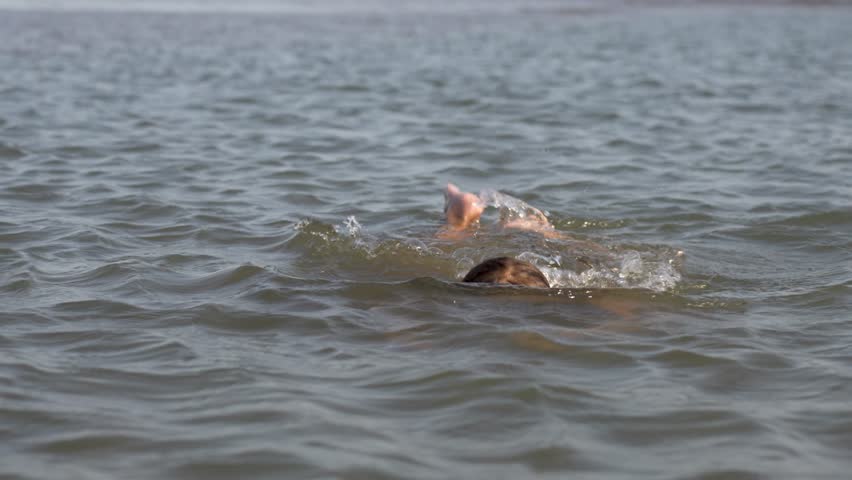 Child girl swimming on a beach sea water. Cute girl diving into ocean water