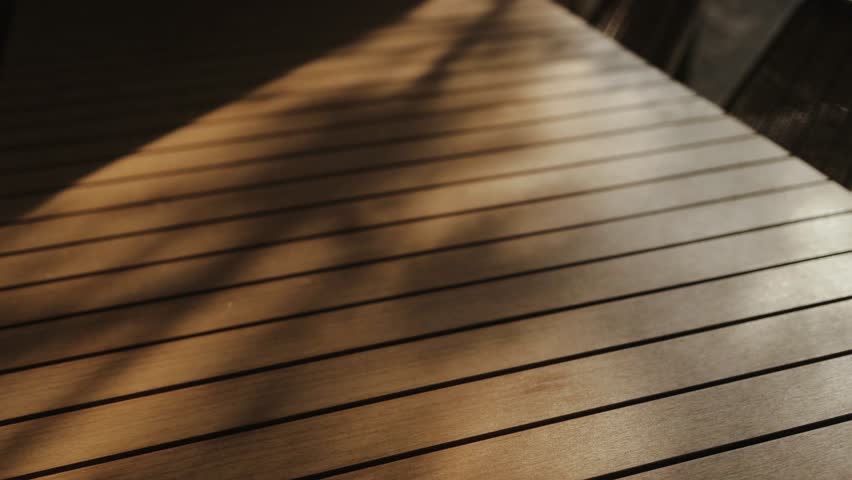 An Elegant Wooden Deck Featuring a Beautiful Play of Light and Shadows Throughout the Day