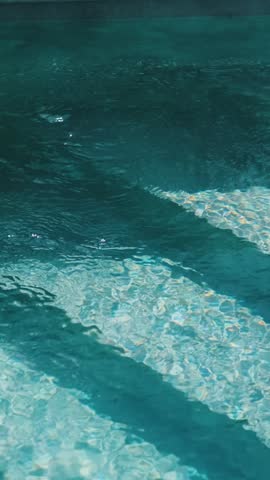 Steps in the pool with blue ceramic tile mosaic. Relax in the backyard of a country house
