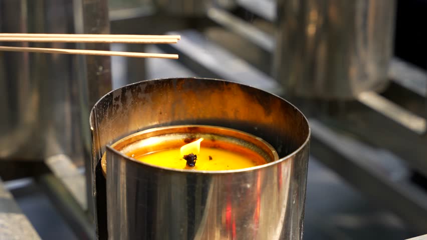 Incense sticks are lit from a candle at Lama Temple in Beijing, China
