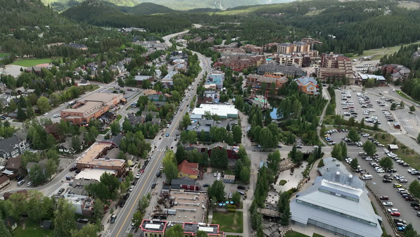 Rotating Aerial Reveal Of Downtown Breckenridge, Colorado With Traffic, People and A Background Mountainscape With Green Trees