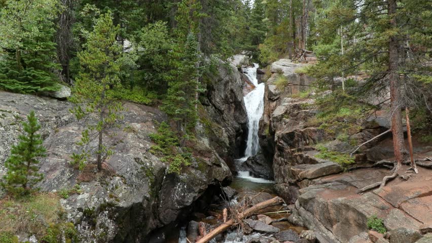 Beautiful vertical clip of a small waterfalls in the Rocky Mountains