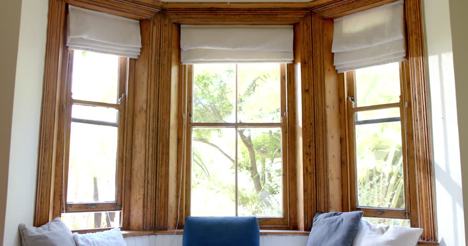 Big living room with couch and pills at big wooden windows. House, desing and architecture.