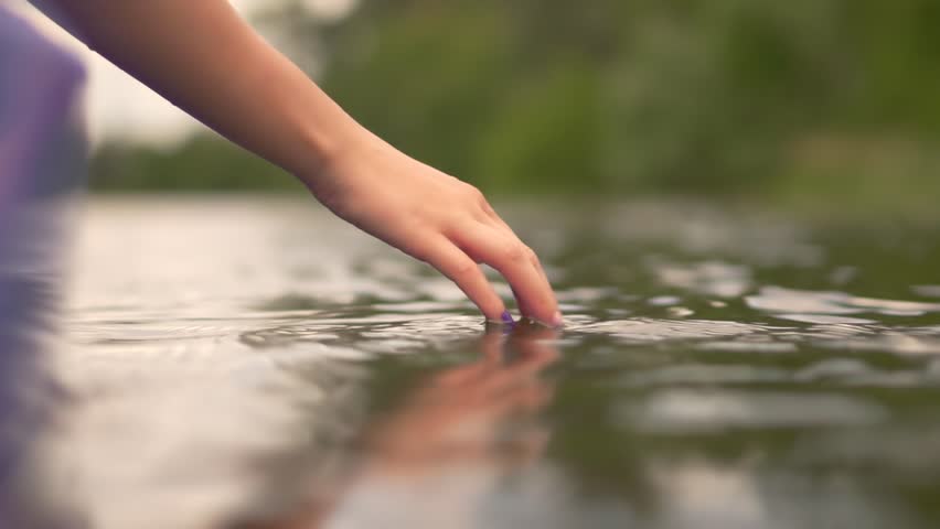 Gently Hands Playing And Touching Water In Lake. Woman Having Fun On Holiday Vacation Weekend Trip.Dragging And Sliding Woman Hand Through Water Surface.Girl Hand With Fingers Sliding On Pond Surface
