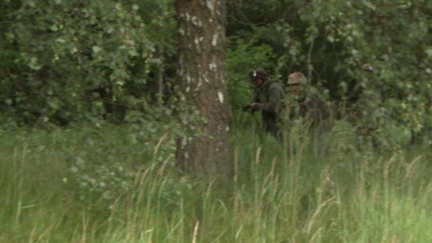 Soldiers running through field, slow motion