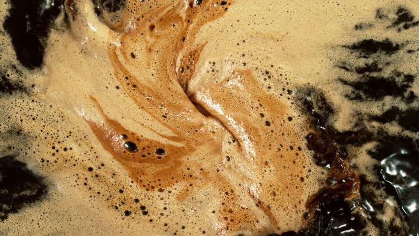 Super Slow Motion Detail Shot of Coffee Foam Swirling . Filmed on High Speed Cinematic Camera at 1000 FPS .