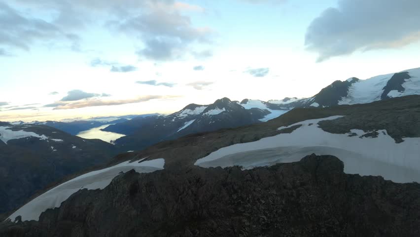 Peak of an alpine mountain over a glacial lake. 