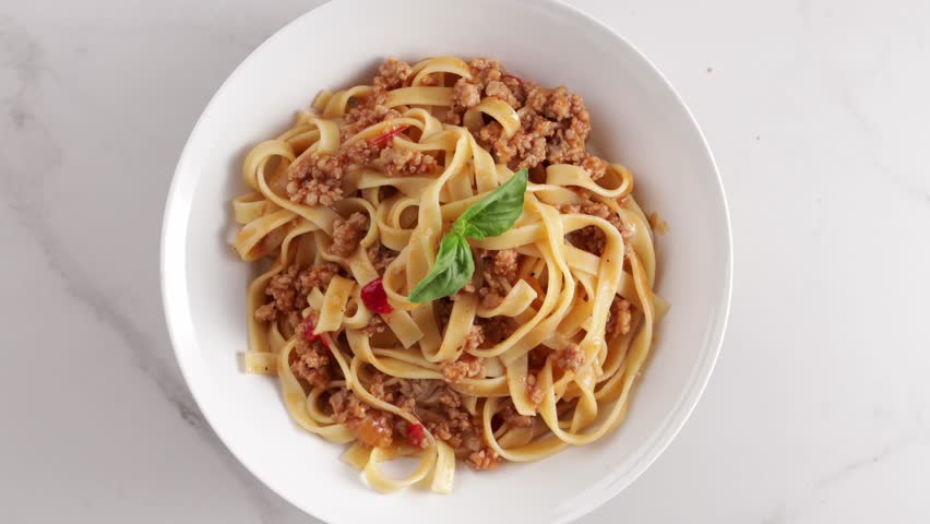 rotation top view of pasta tagliatelle bolognese sauce white bowl food