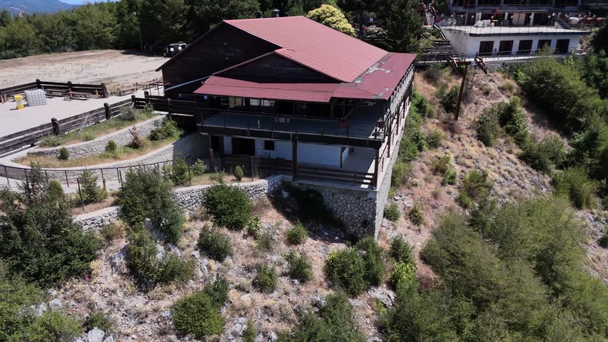 Camera panning around a large building on a mountainside