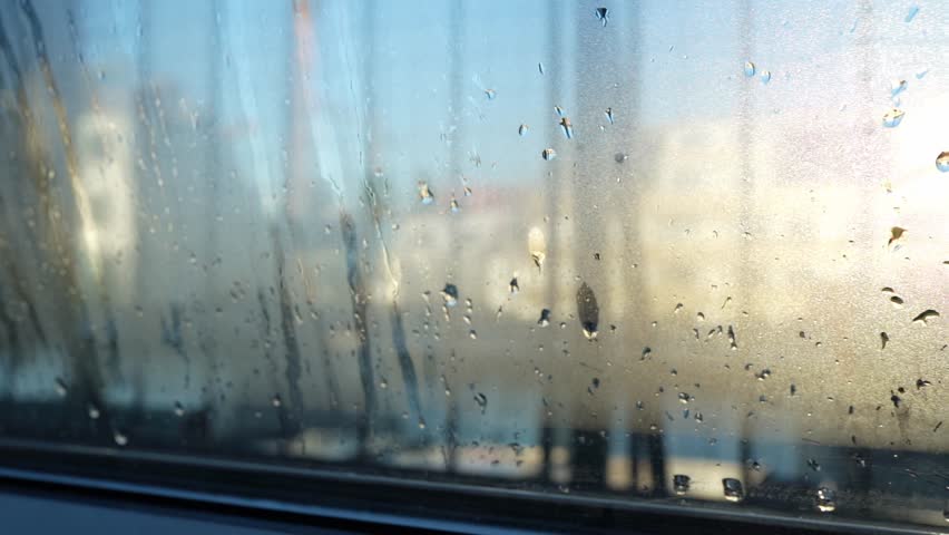 Condensation forming on double glazed window. Contrast cold air and humidity. Drops on glass. Cold room. Backlight poor glass sealing