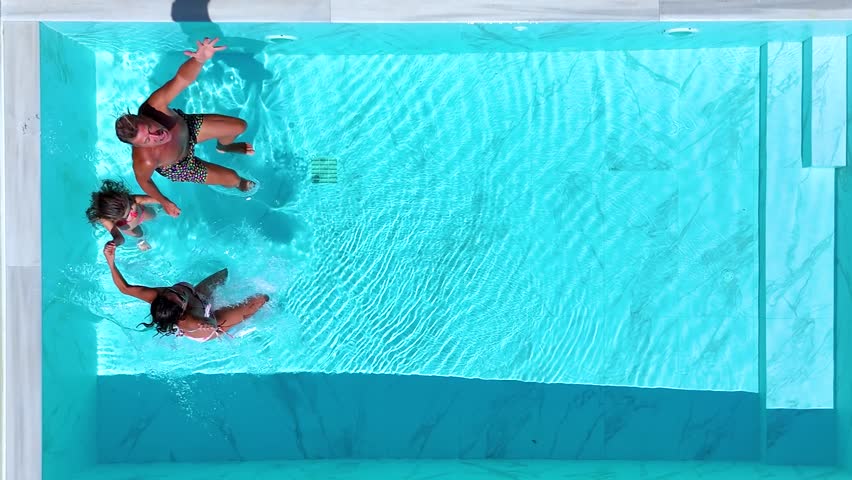 Aerial top view of a happy family jumping together in the pool as a summer travel concept with copy space