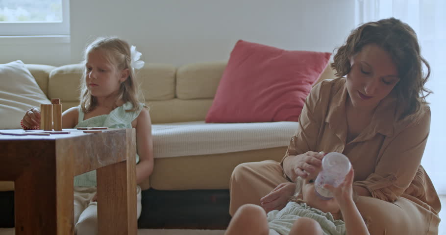 Mother and her two daughters enjoying quality time together in their living room