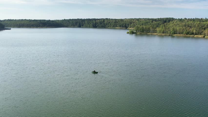 a lonely fishers boat in the middle of the lake