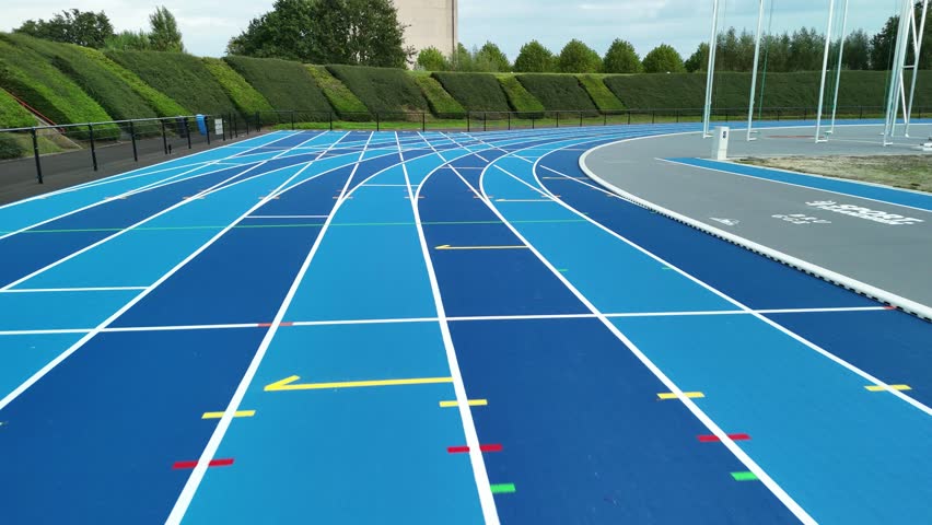 A blue running track at an athletics stadium on a clear day