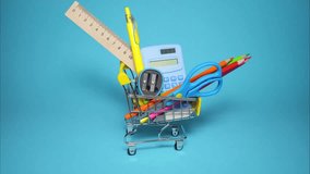 Shopping cart with school supplies spins round on blue background. Back to school concept. Preparing for school, buying stationery concept. Stop motion animation. Copy space - Powered by Shutterstock - Get 15% off with code: PIKWIZARD15