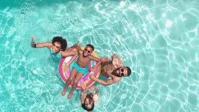 Aerial of african american parents, son and daughter on inflatable in sunny pool waving, copy space. Summer, family, fun, togetherness, vacations, free time, relaxation and lifestyle, unaltered. - Powered by Shutterstock - Get 15% off with code: PIKWIZARD15