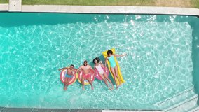 Aerial of african american parents, son and daughter lying on inflatables in sunny pool, copy space. Summer, family, fun, togetherness, vacations, free time, relaxation and lifestyle, unaltered. - Powered by Shutterstock - Get 15% off with code: PIKWIZARD15