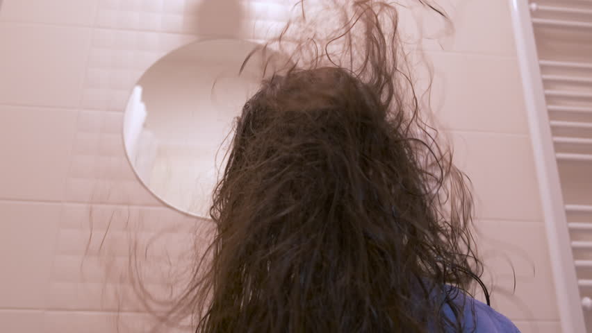 Dry your hair with a hair dryer. Back view of the long wet hair of a little girl blowing warm air from a hair dryer.