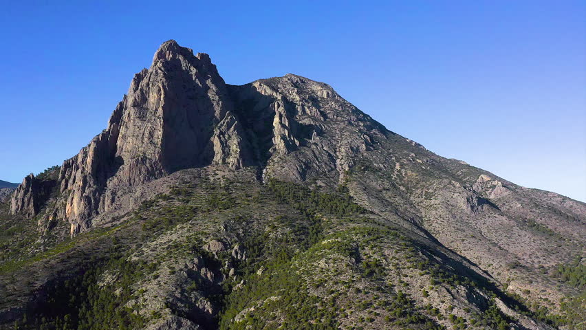 Aerial view of mount Puig Campana and pine forest around, next to Villajoyosa Village in the Mediterranean Sea, Alicante, Spain.