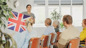 Interesting story about Great Britain while teaching university adult students. Teacher holds the flag of Great Britain in her hands. High quality 4k footage - Powered by Shutterstock - Get 15% off with code: PIKWIZARD15