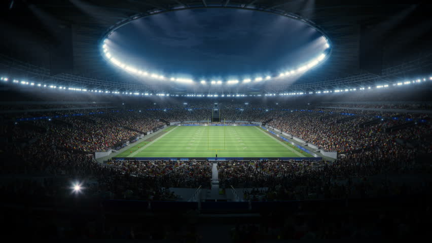 Night Aerial View of a Crowded American Football Stadium With Fans Filling the Stands. the Field Is Prepared for a Major Championship Match. Forward Flyover Establishing Shot