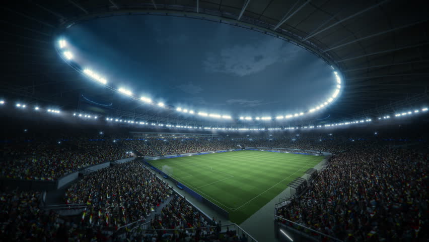 Night Soccer Match in a Massive Stadium Filled With Spectators. the Arena Is Packed With Fans Surrounding the Green Pitch, Ready for a Major Sport Event. Static Establishing Cinematic Shot