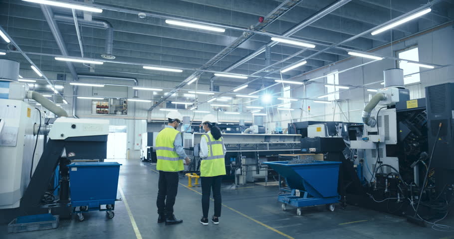 Two Engineers in Safety Vests Use a Tablet to Interact With Holographic Data in a High-tech Factory, Activate AI Facility Analysis, Advanced Machinery, Digital Interfaces, Futuristic Manufacturing