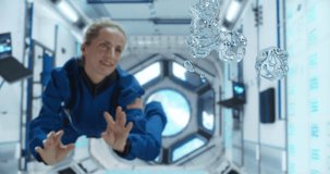 Female Cosmonaut in a Blue Suit Interacts With Floating Water Droplets Inside a Space Station, Capturing the Unique Behavior of Liquids in Microgravity. - Powered by Shutterstock - Get 15% off with code: PIKWIZARD15