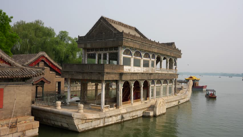 Tourists on a small boat explore the Summer Palace lake near the Marble Boat in Beijing