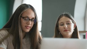 Business teamwork online. People collaborating on laptops in modern cafe. Teamwork and online business. Two women discuss ideas. People work together use laptops. Online teamwork and business strategy - Powered by Shutterstock - Get 15% off with code: PIKWIZARD15