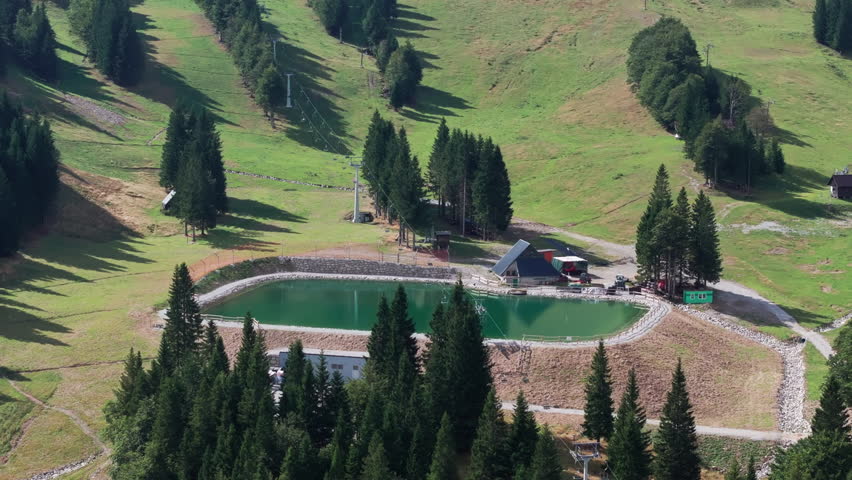 Summer view of ski slope with reservoir of water