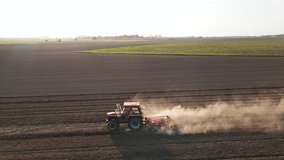 Red tractor working in agricultural field, cultivating and plowing dry soil, aerial view. Agribusiness concept. Small farming concept - Powered by Shutterstock - Get 15% off with code: PIKWIZARD15