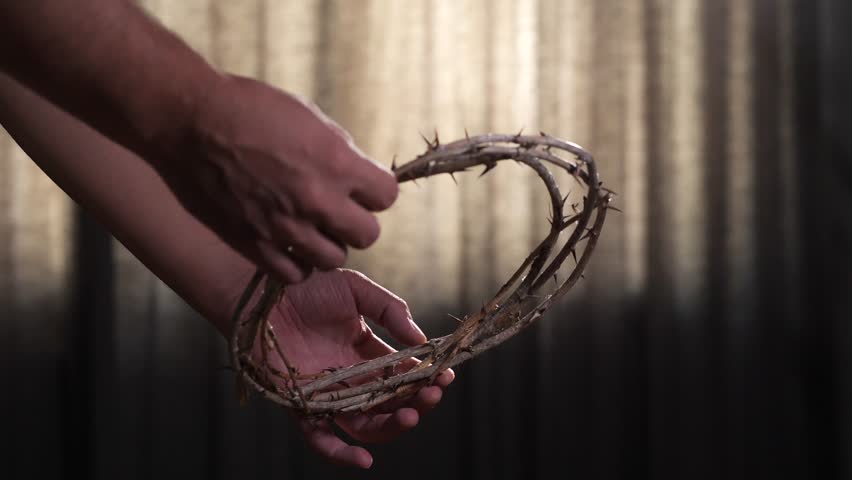 Priest grasping a crown of thorns as a symbol of christ