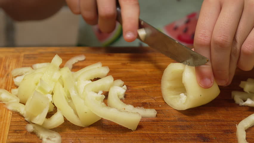 Chopping Green Pepper on a Wooden Cutting Board