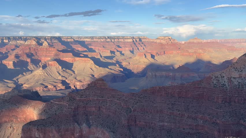 Slow panning shot of a beautiful sunset over the Grand Canyon National Park in Arizona with red rock formations, stunning colors and vast canyon views. Perfect for travel, nature, and adventure - USA