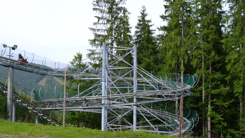All-weather toboggan run in Bukovel Speed Fun, rodelbahn with many curves on a mountain. An attraction for an exciting descent with twists, turns and jumps thwt create a special thrill
