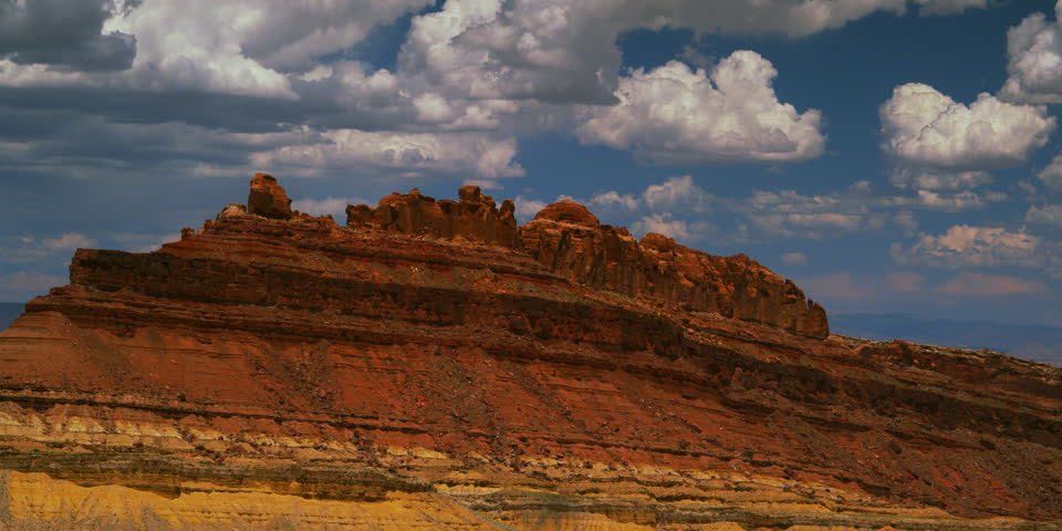 Dreamy cumulus clouds float above the San Rafael Swell, Utah on an idyllic summer day.