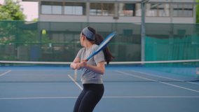 Asian young sportswoman playing tennis on the court during sport match. Attractive athlete female player serving and hitting the ball with racket, practicing tennis game to exercise workout for health - Powered by Shutterstock - Get 15% off with code: PIKWIZARD15