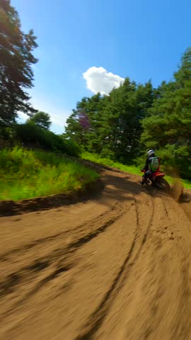 Dynamic FPV shot of a racer on a motocross bike on a track at high speed. Concepts of extreme sports, adrenaline, and racing.