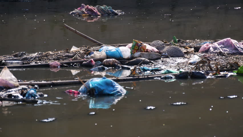 Flowing river with plastic and garbage pollution. River full of plastic bottles and toxic chemicals.