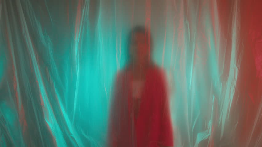 A woman in a pink blazer is trying to get out of plastic wrap 